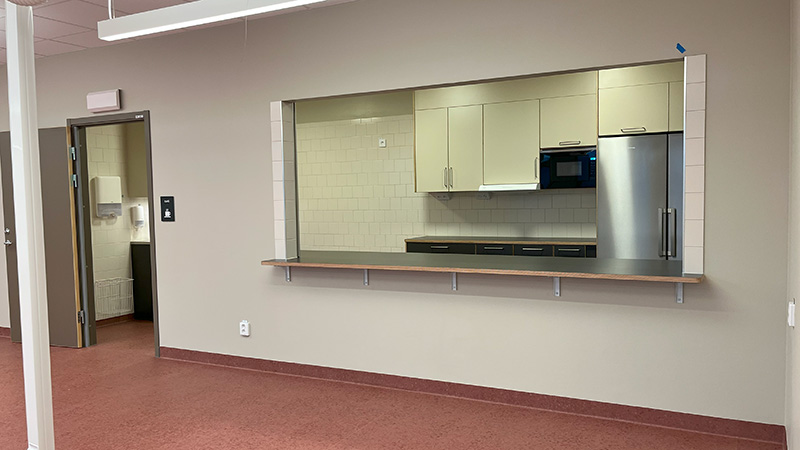 Ett kök i ett anslutande rum.