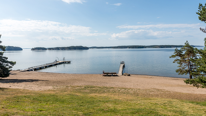 sandstrand med brygga vid havet
