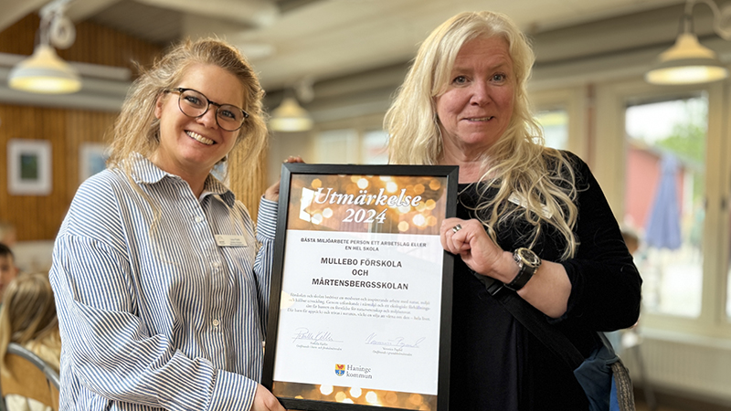 Två kvinnor håller upp ett diplom