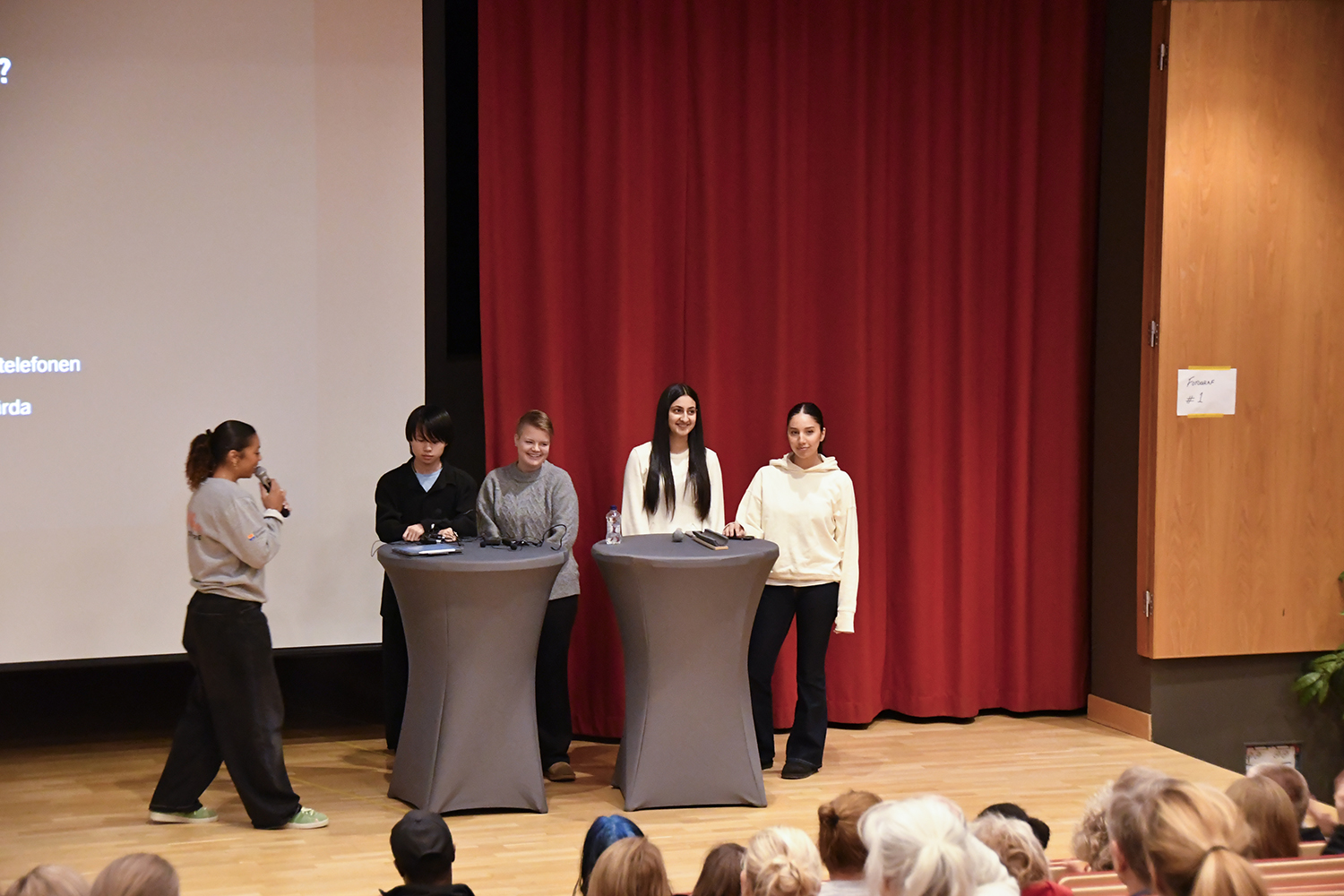 Paneldiskussion med moderatorn och fyra ungdomar på scen under föreläsningskvällen.