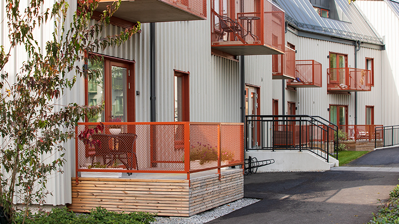 Röd balkong och uteplats på ett grått trähus