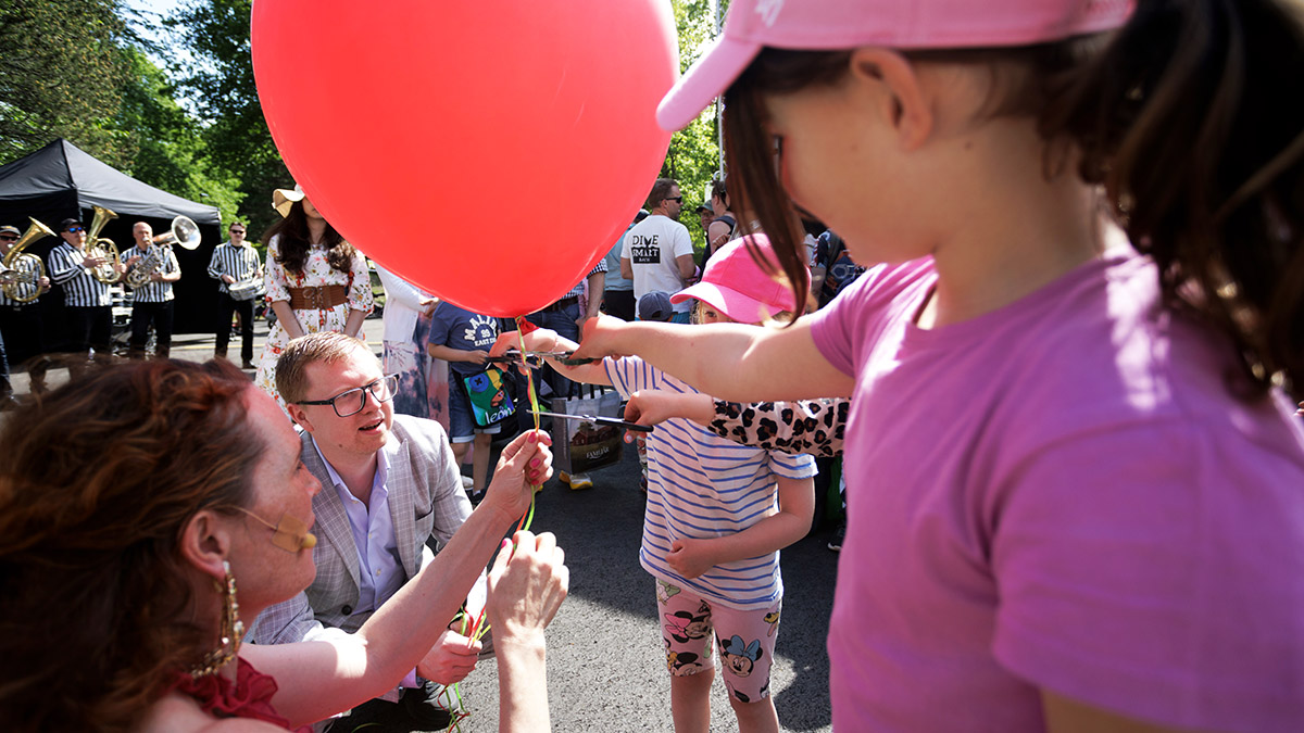 Barn som håller i en röd ballong
