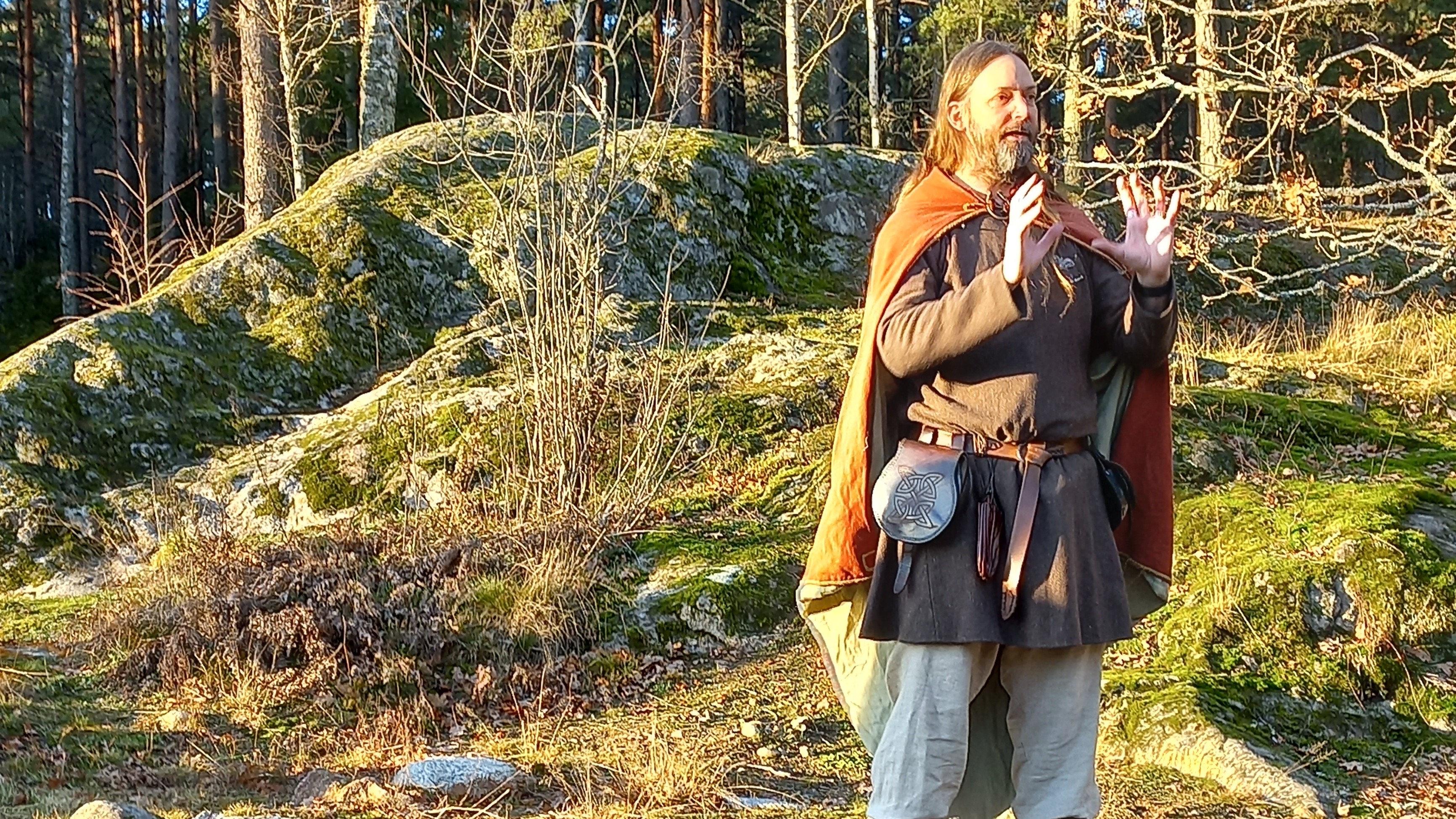 Bild på en person som står vid Jordbro gravfält