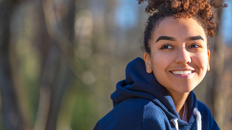 En glad tjej sitter i naturen