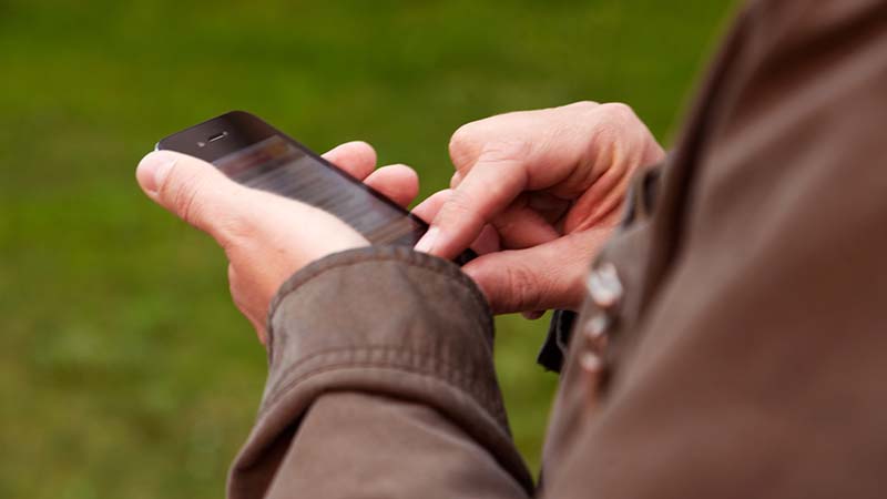 En hand som håller i en mobiltelefon