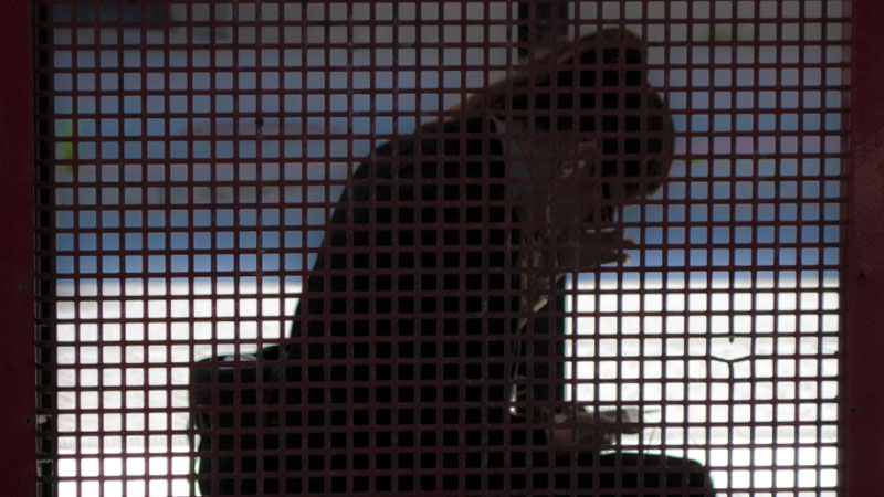 Silhuett av kvinna som sitter framåtböjd