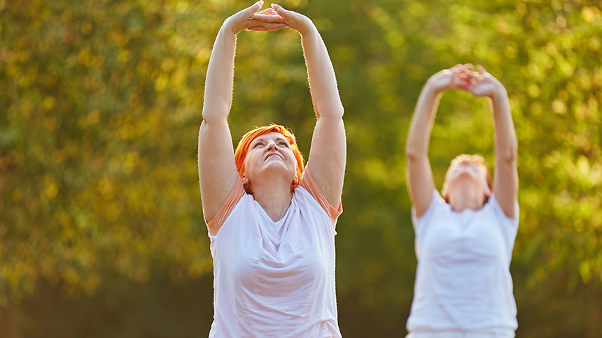 Två personer sträcker armarna i luften